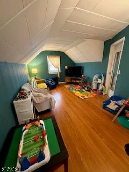 rec room featuring vaulted ceiling and wood finished floors