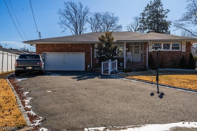 single story home with aphalt driveway, brick siding, and an attached garage