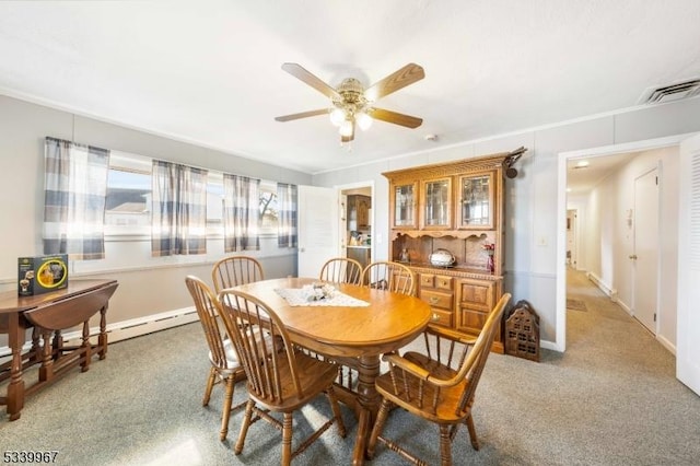 carpeted dining space with a baseboard heating unit, ceiling fan, visible vents, and baseboards