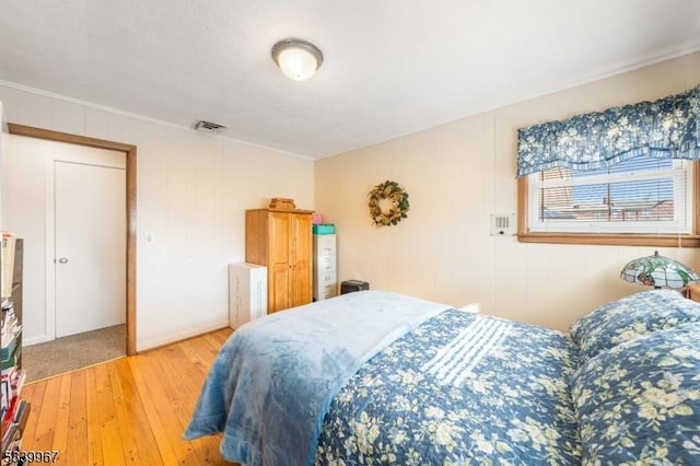 bedroom featuring visible vents and wood finished floors