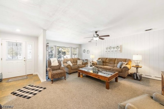 living room with light carpet, baseboards, visible vents, a ceiling fan, and a baseboard heating unit