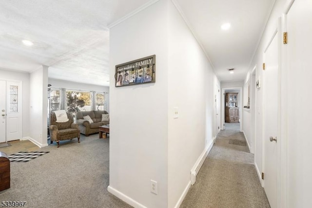 hallway featuring light carpet, baseboards, and ornamental molding