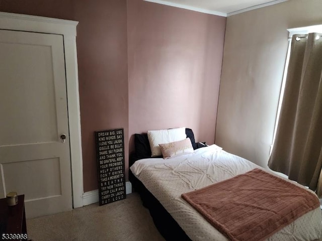 bedroom featuring ornamental molding and carpet