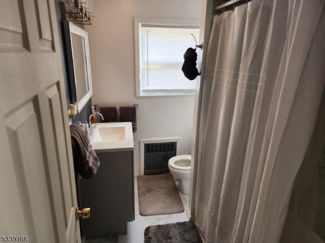 full bathroom with radiator, vanity, toilet, and tile patterned floors