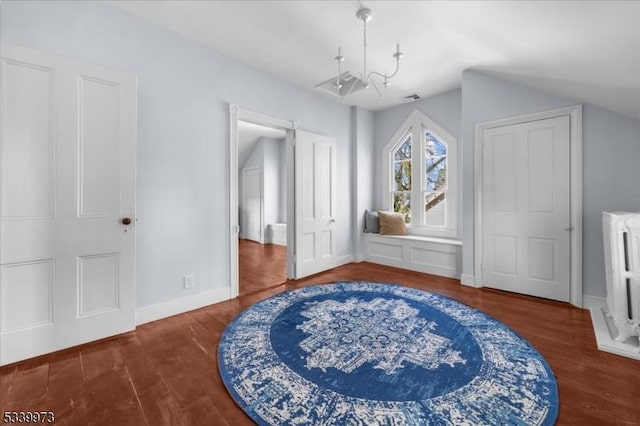 interior space featuring visible vents, baseboards, radiator, wood finished floors, and a chandelier