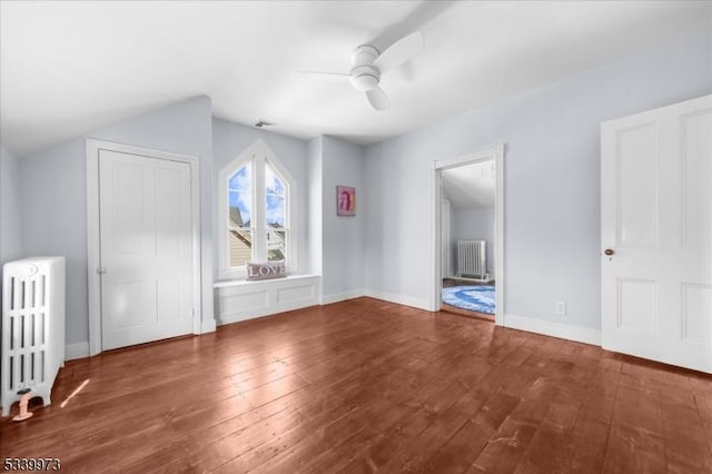 bonus room with baseboards, hardwood / wood-style floors, a ceiling fan, and radiator