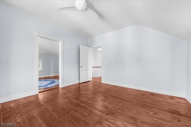 interior space featuring lofted ceiling, a ceiling fan, baseboards, and wood finished floors