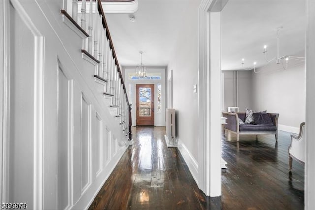 foyer entrance with radiator, baseboards, stairway, and dark wood-style flooring