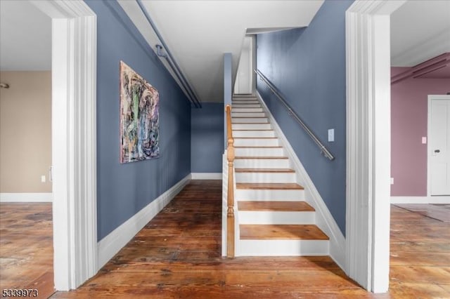 staircase with baseboards and hardwood / wood-style flooring