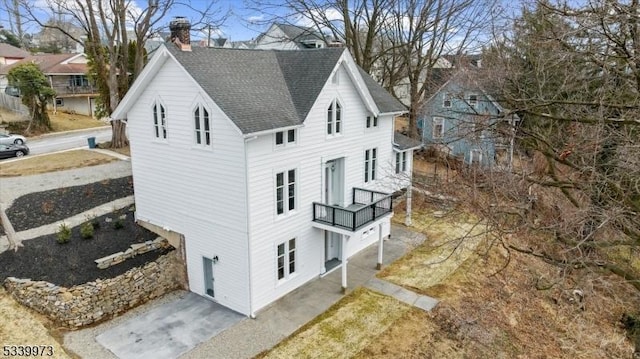 view of home's exterior featuring a shingled roof and a chimney