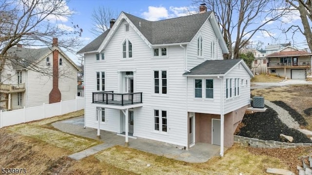 back of property with a patio, cooling unit, a balcony, fence, and a chimney