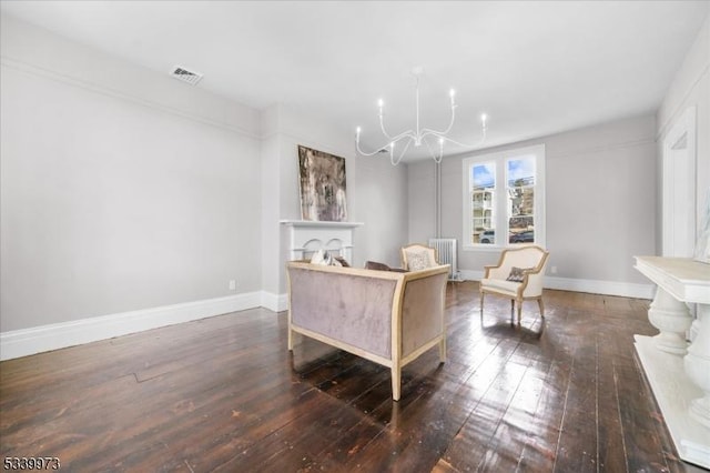 living area with an inviting chandelier, a fireplace, hardwood / wood-style flooring, and baseboards