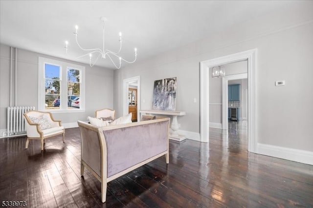 living room featuring hardwood / wood-style floors, radiator heating unit, baseboards, and a notable chandelier