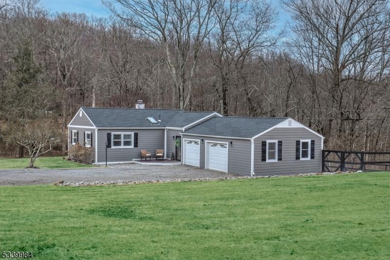 view of front facade featuring a front yard, fence, driveway, a chimney, and a garage