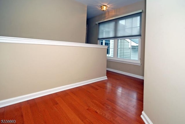 hall featuring baseboards and wood finished floors