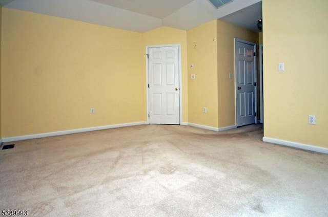 empty room with carpet, visible vents, and baseboards