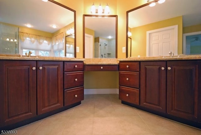 bathroom featuring baseboards, a stall shower, vanity, and tile patterned floors