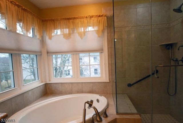 bathroom with a stall shower and a bath