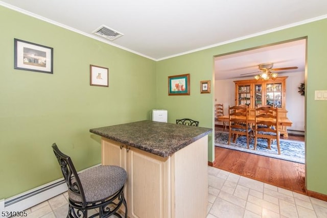 kitchen with visible vents, a ceiling fan, dark countertops, crown molding, and baseboard heating