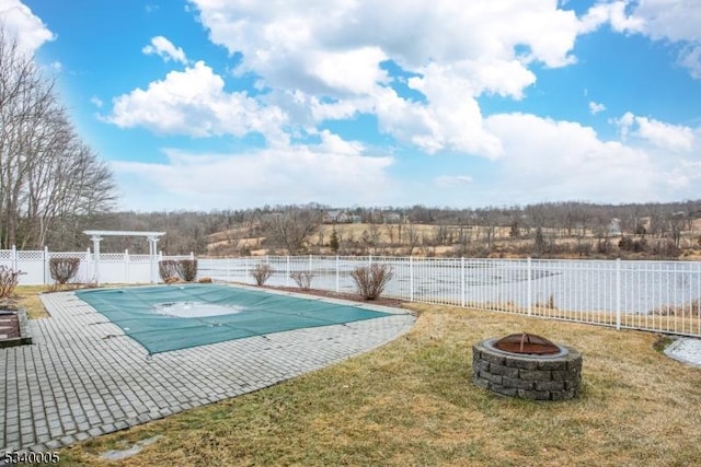 view of swimming pool featuring a fenced in pool, an outdoor fire pit, a yard, a fenced backyard, and a patio area