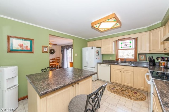 kitchen with dark countertops, a kitchen island, crown molding, white appliances, and a sink