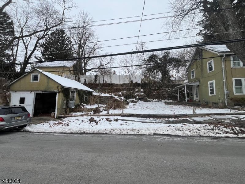 snowy yard featuring an outbuilding and a detached garage