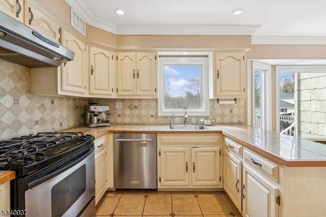 kitchen featuring a peninsula, a healthy amount of sunlight, under cabinet range hood, and stainless steel appliances