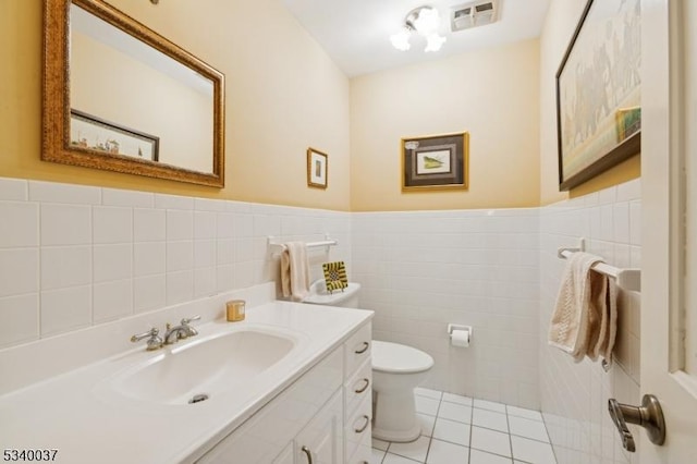 bathroom featuring vanity, a wainscoted wall, visible vents, tile patterned flooring, and toilet