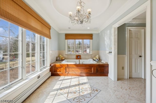 full bath featuring a wainscoted wall, an inviting chandelier, a baseboard heating unit, crown molding, and a bath