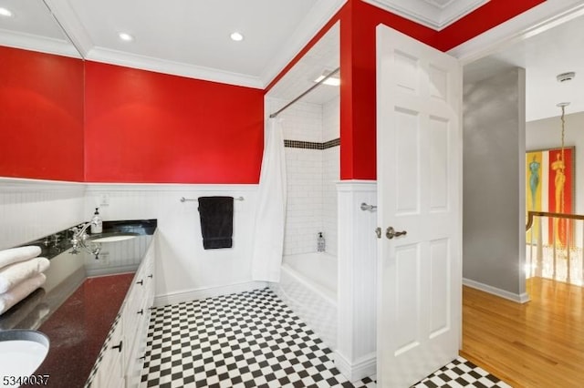 bathroom with shower / tub combo with curtain, ornamental molding, a sink, wainscoting, and double vanity