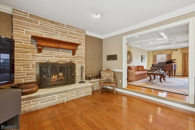 living area featuring crown molding, beamed ceiling, a fireplace, wood finished floors, and coffered ceiling