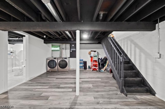 basement featuring stairs, wood finished floors, and separate washer and dryer