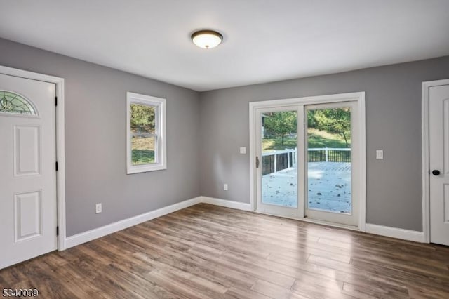 interior space with a healthy amount of sunlight, baseboards, and dark wood-type flooring