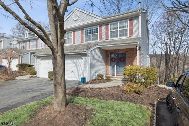 view of front of home with a garage, aphalt driveway, and brick siding