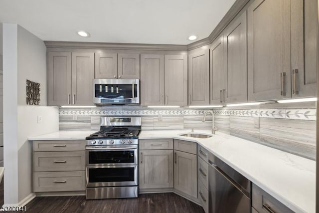 kitchen with appliances with stainless steel finishes, gray cabinets, light countertops, and a sink