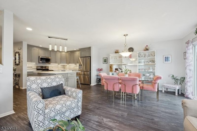 interior space featuring dark wood-style floors, recessed lighting, a notable chandelier, and baseboards