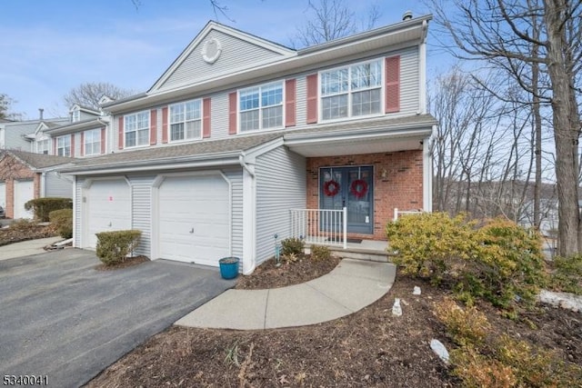 view of front of house featuring driveway, brick siding, and an attached garage