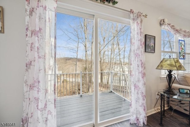 doorway featuring baseboards and wood finished floors