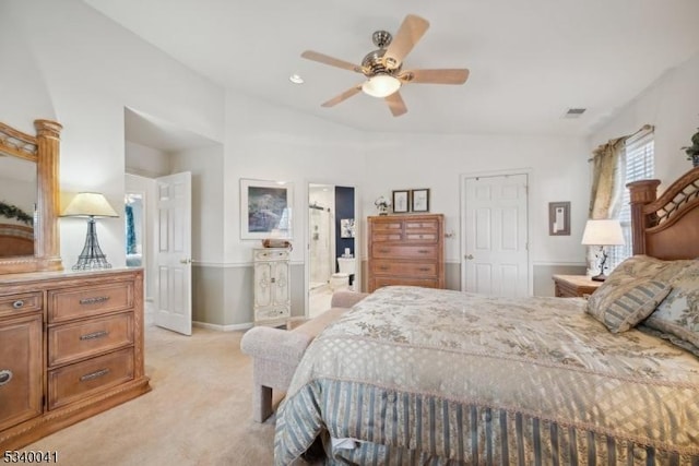 bedroom with visible vents, ensuite bathroom, light carpet, vaulted ceiling, and baseboards