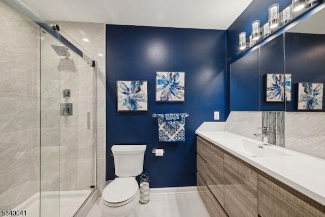 bathroom featuring toilet, a stall shower, baseboards, and vanity