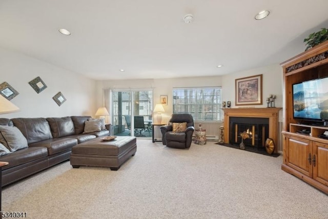 carpeted living room featuring a fireplace with flush hearth and recessed lighting