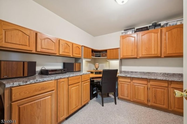 kitchen with built in study area and brown cabinets