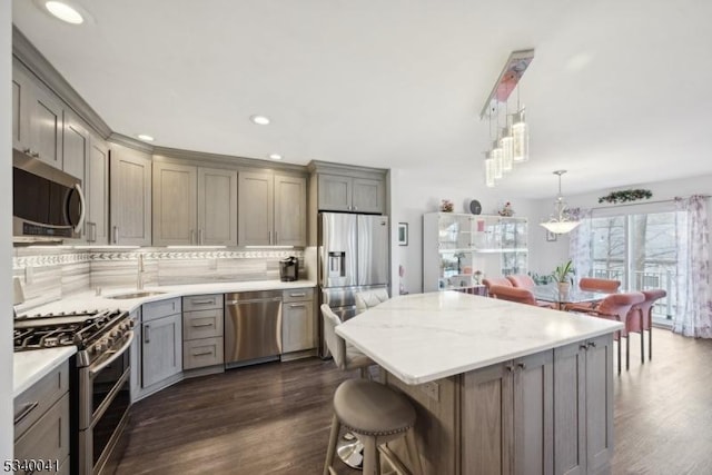 kitchen with dark wood finished floors, appliances with stainless steel finishes, gray cabinets, and a sink