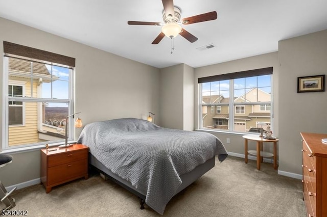 bedroom featuring visible vents, baseboards, ceiling fan, and light colored carpet