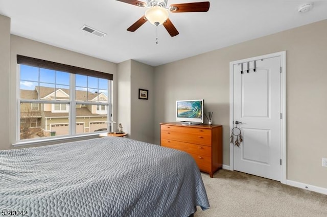 bedroom featuring baseboards, visible vents, a ceiling fan, and light colored carpet