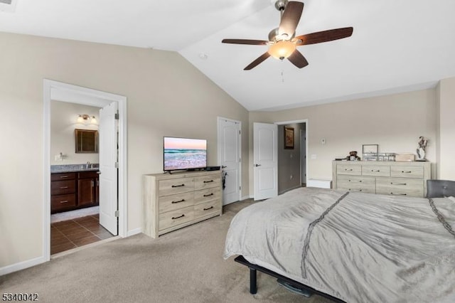 bedroom featuring light carpet, baseboards, connected bathroom, lofted ceiling, and a sink