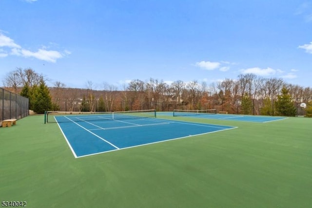 view of tennis court featuring fence