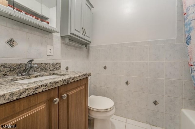 bathroom featuring tile patterned flooring, toilet, tile walls, and vanity