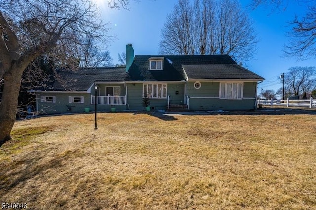 view of front facade featuring a chimney and a front yard