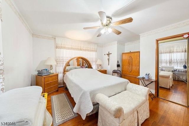 bedroom featuring ceiling fan, ornamental molding, and wood finished floors